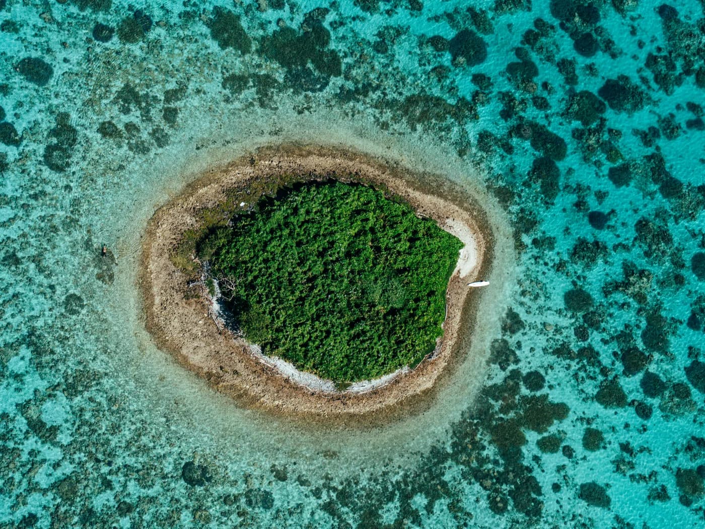 Un îlot rond et végétalisé entouré de récifs turquoise à Bourail