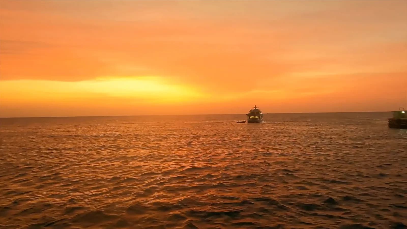 Le soleil se couche dans un ciel orange au-dessus de la mer